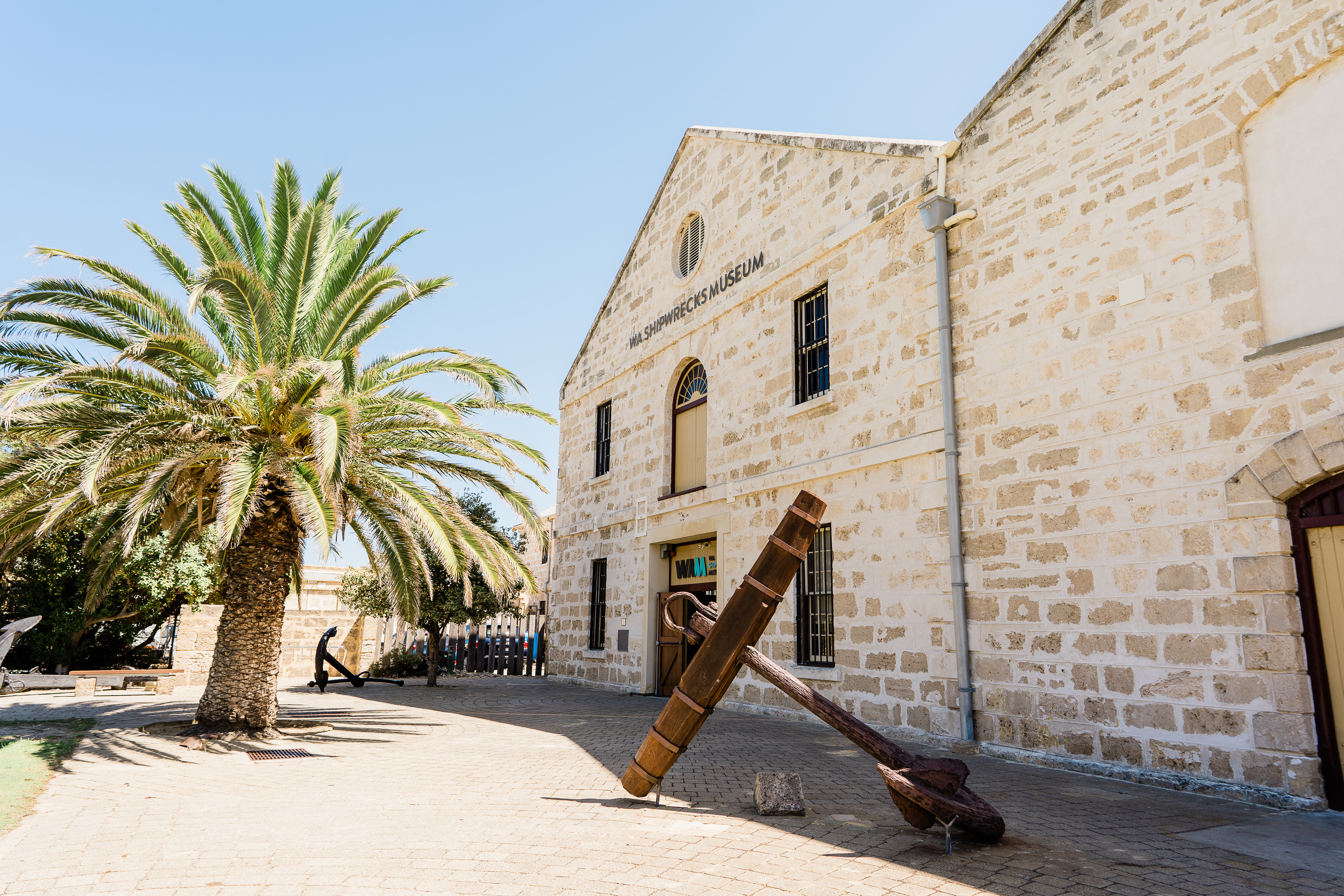 The entrance to Shipwrecks Museum, the building set against blue sky with a green palm tree to the left of the image