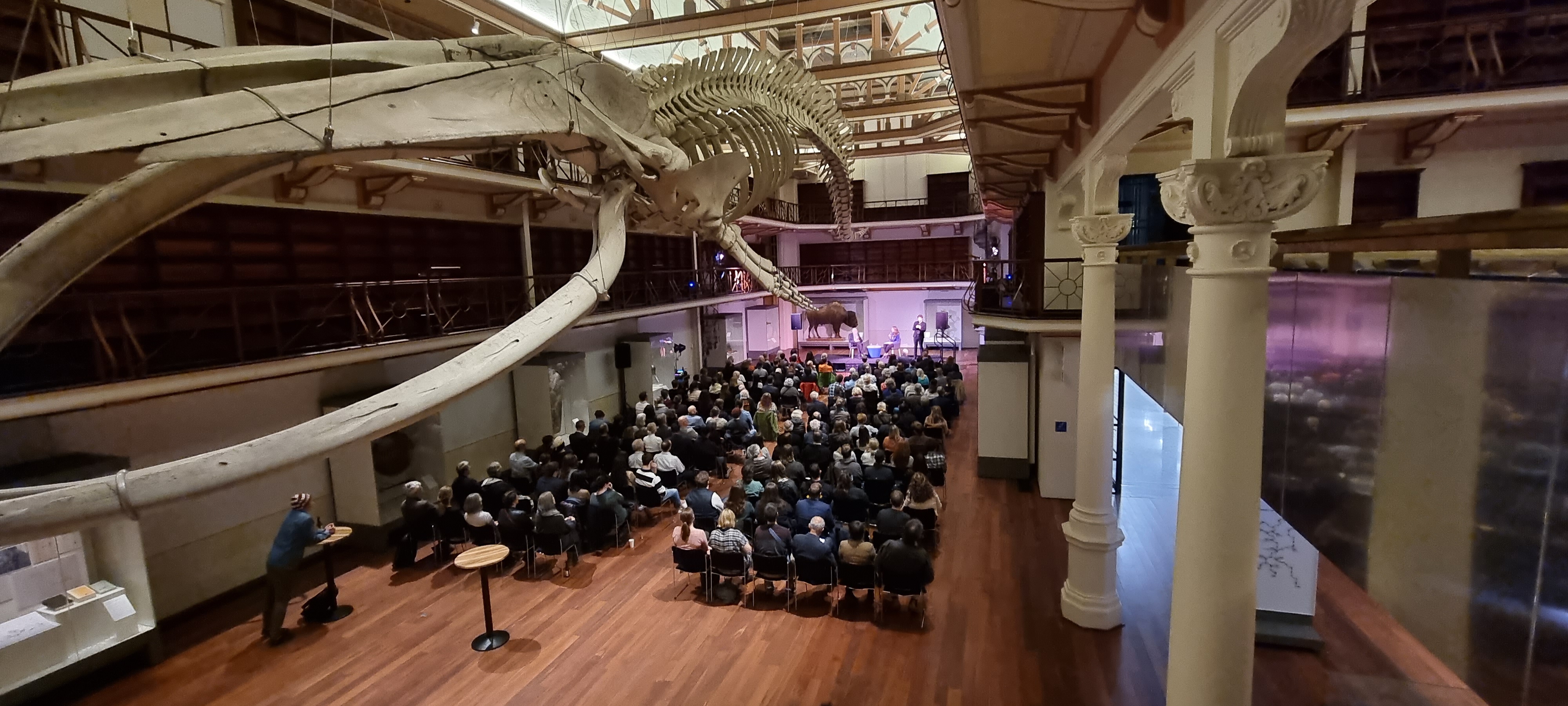 High view of Hackett Hall with chairs set up to face a small stage with speakers