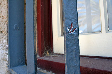 A broad arrow carved into a window bar of the WA Shipwrecks Museum