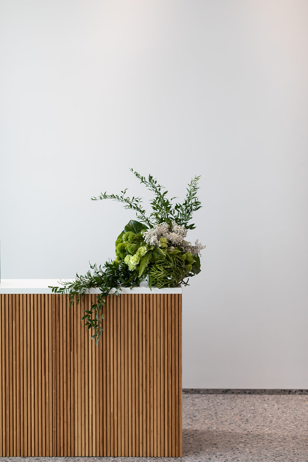 A bouquet of flowers displayed in front of a white wall