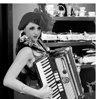 a person wearing feathery outfit holds a piano accordion and playing it