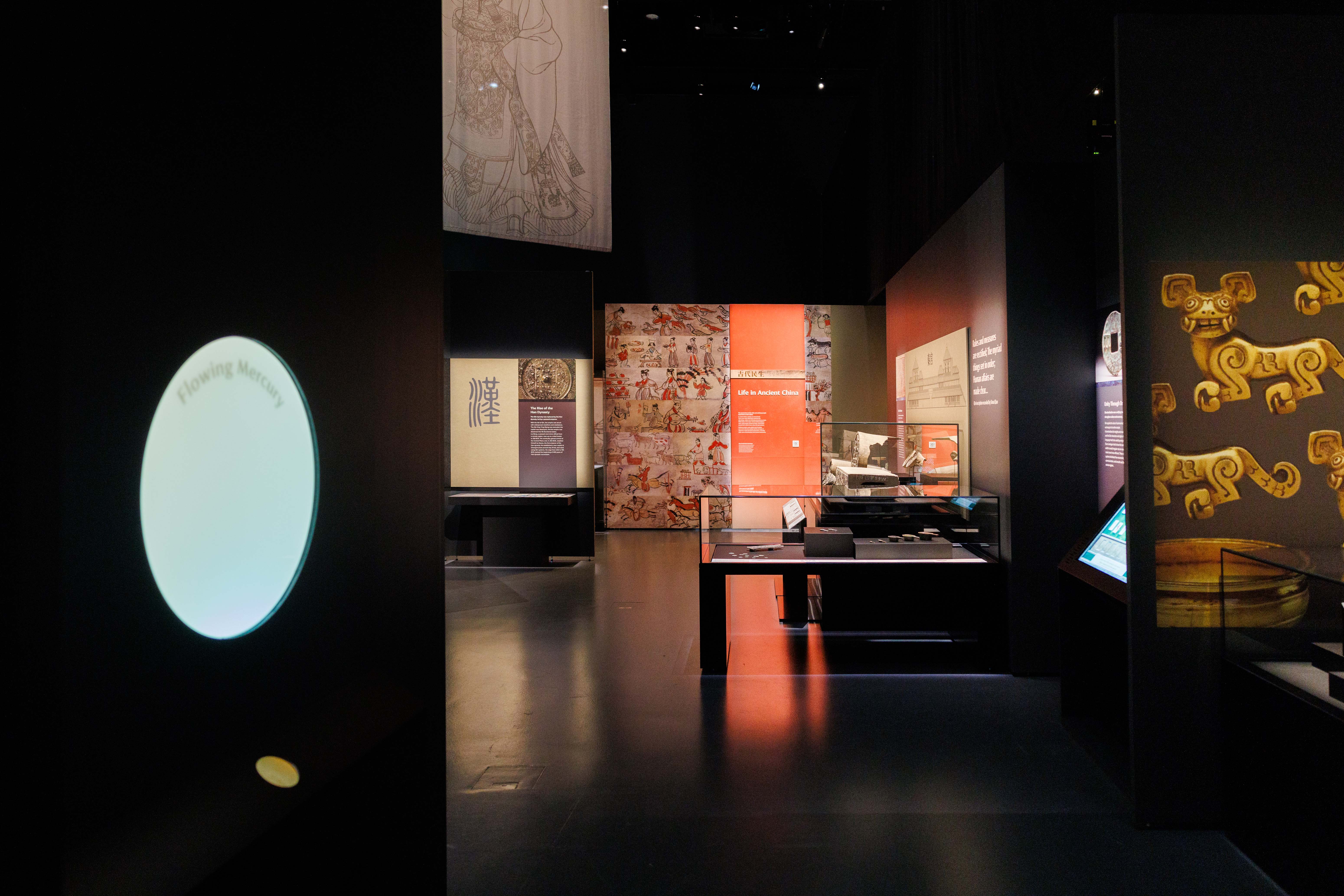 Museum exhibit with displays about ancient China, including projected text and artefacts.