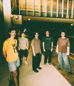 Five men standing at a train station