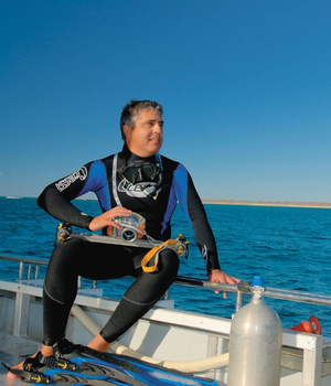 Man sitting on a boat with wetsuit on