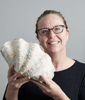 Lady holding clam smiling