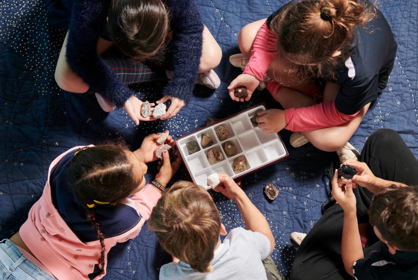 Group of children sitting in a circle looking at rock specimens