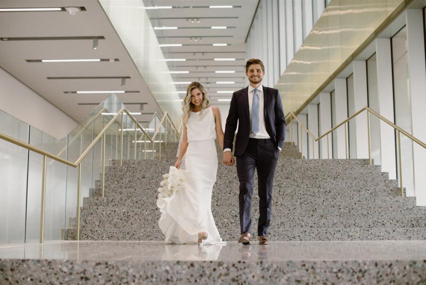 Bride and groom standing side by side on the stairs