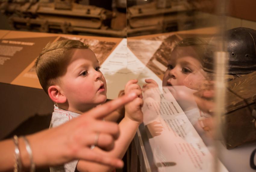 A young child looks into a museum showcase
