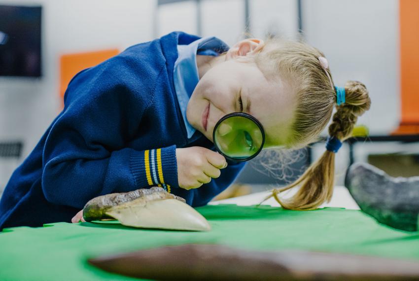 A child looking through a magnifying glass