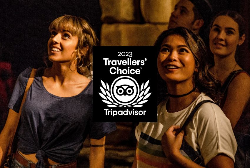 A close up view of the interested faces of a tour group in the WA Shipwrecks Museum. An overlaid logo states '2023 Travellers' Choice, Tripadvisor'.