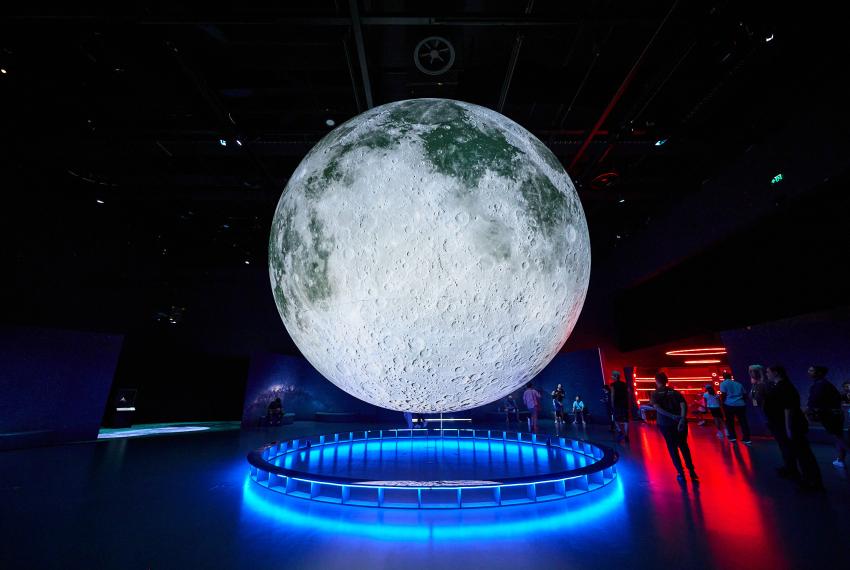 Large, impressive moon installation suspended in mid-air within an exhibition space