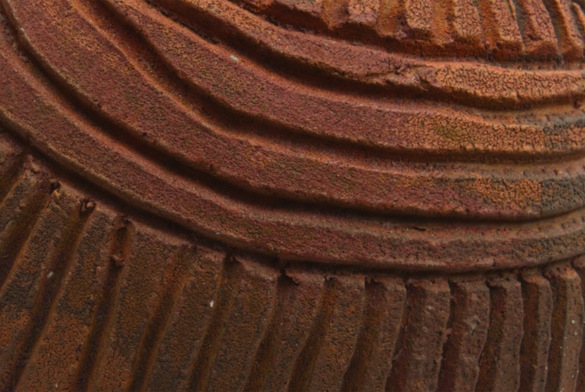 Close up detail of a brown pottery object with lines