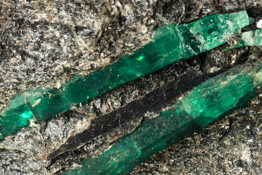 Jade coloured minerals, long, thin and rectangular in shape, surrounded by grey rock