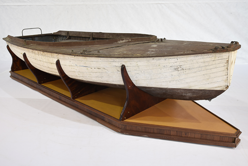 The open built Endeavour is a snub-nosed, carvel planked 14-foot wooden dinghy. It can be rigged as a sloop or a gaff, and has a centreboard, foredeck, and side decks. The hull to the waterline is painted white, while the deck, side benches and underside of the hull are painted brown. The original sail insignia shows the letter “E” inside a red and white diamond.