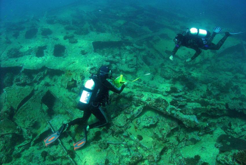 2 divers underwater examining a shipwreck