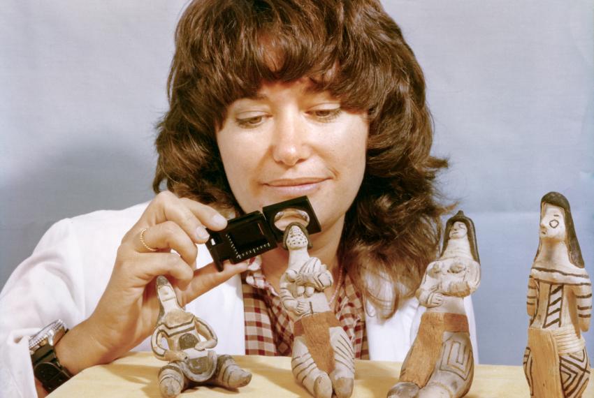 Moya Smith inspecting a series of small artefacts.