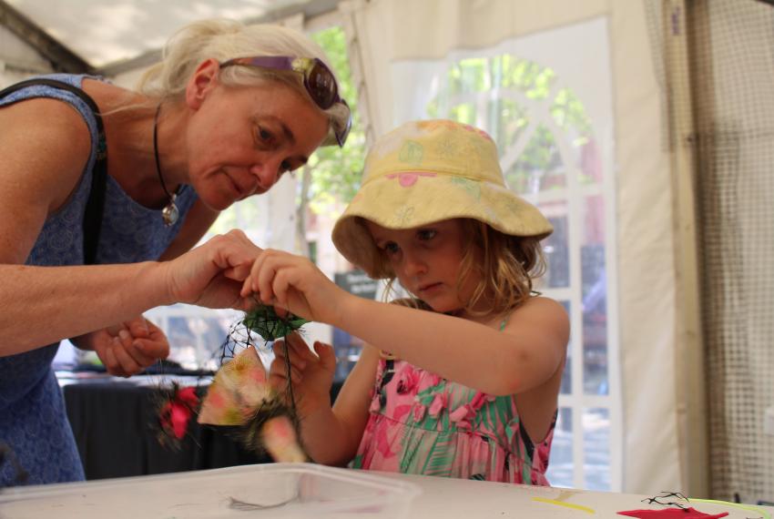 A woman and a young girl work on their contribution to the coral reef at AWESOME Festival