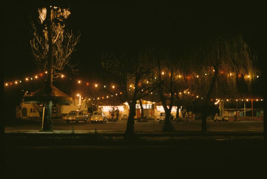Bernies from afar at night time with its lights on, surrounded by festoon lights