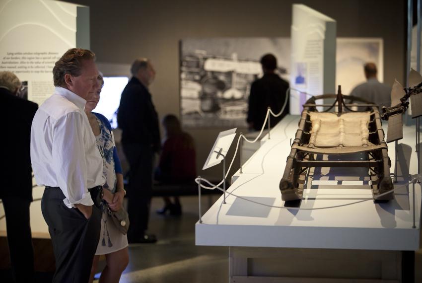 Visitors inspecting a display at the exhibition Traversing Antarctica