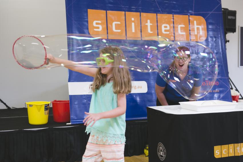 A child playing with a large bubble at Science Wonderland