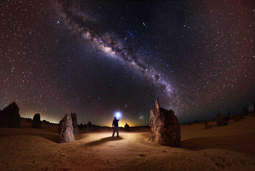 Man standing under night sky at Nambung National Park.