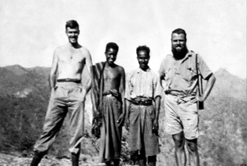 Two Australian soldiers standing with two young East Timorese men, known as criados