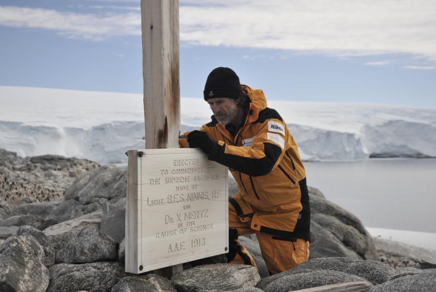 Ian Godfrey documenting the replica plaque attached to the Memorial Cross at Cape Denison