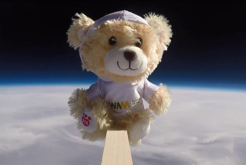Nugget the teddy bear floating above the curvature of the Earth