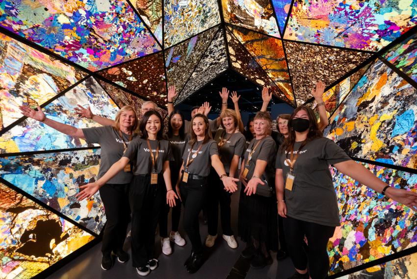 Western Australian Museum volunteers pose for a group photo underneath the Museum's colourful mineral archway