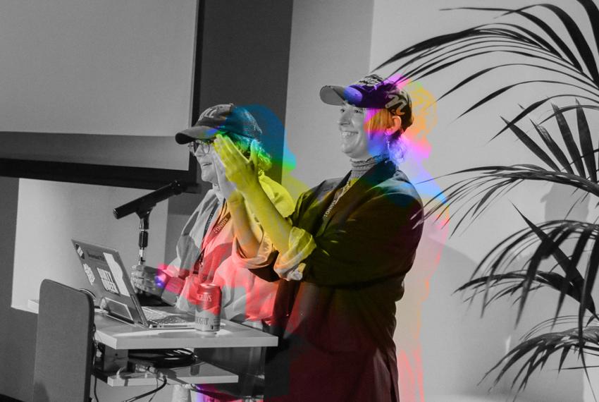 Queer Powerpoint hosts Xanthe Dobbie and Harriet Gilles clap and present during Queer PowerPoint at WA Museum Boola Bardip.