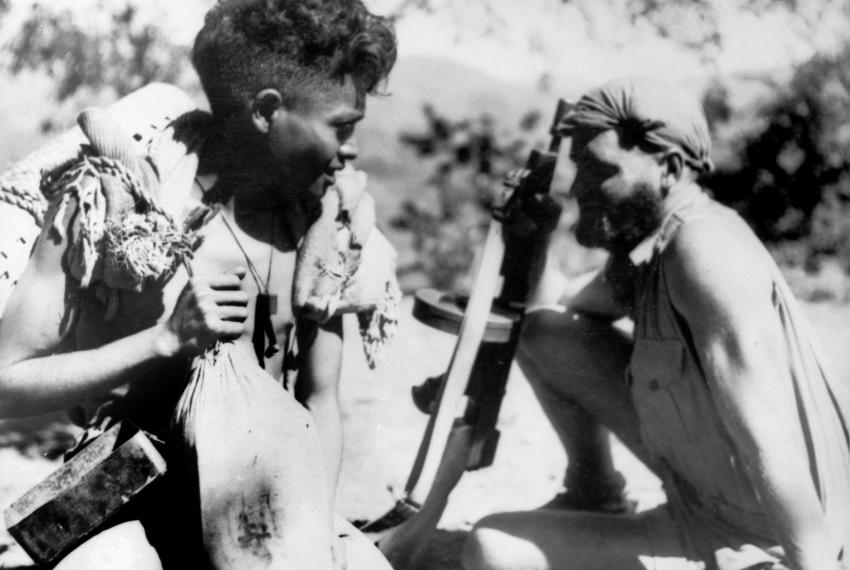Australian soldier sitting next a criado during World War Two in East Timor