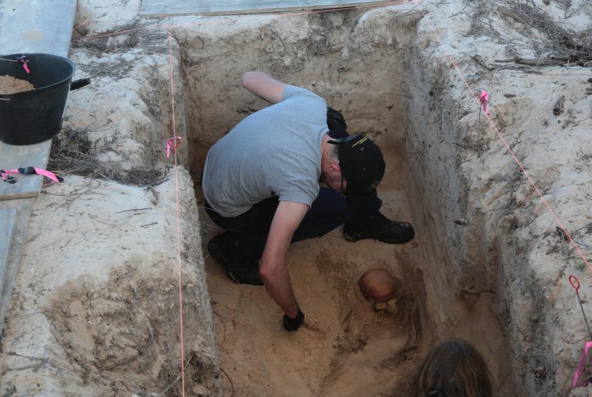 Archaeologist carefully excavating new burial site at Beacon Island.