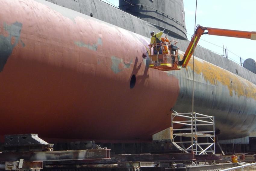 Conservation work being performed on a large submarine
