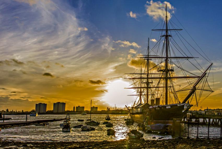 a sunset image of a ship in a marina 
