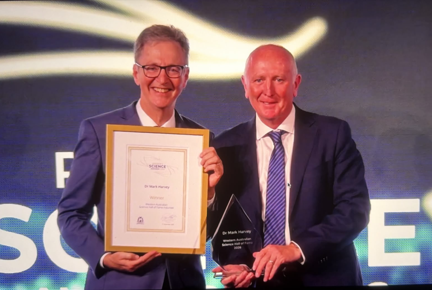 Mark Harvey stands next to Stephen Dawson holding a large framed certificate