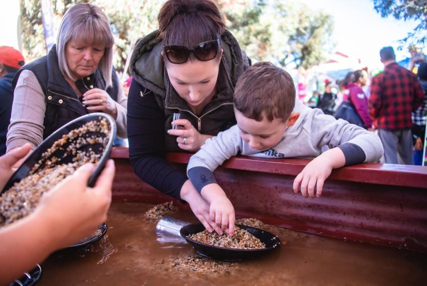 Mother and son shift through dirt to find gold