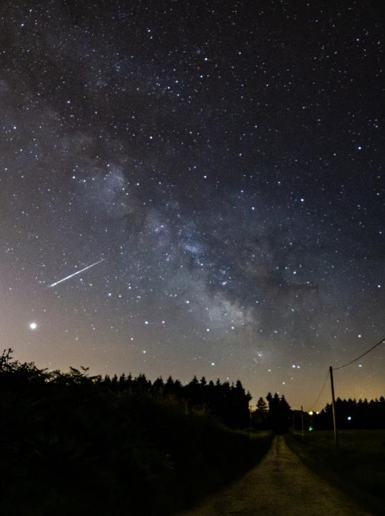 Image of the night sky showing a meteorite streak as passes through the atmosphere. falling to Earth streak 
