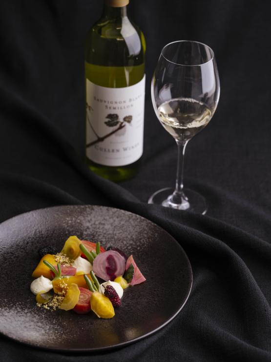A plate of food, wine glass and wine bottle 