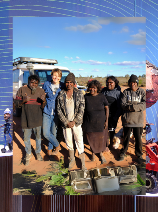  A group of people smiling while standing in front of a white four-wheel drive, set against the vibrant red dirt landscape of Australia.