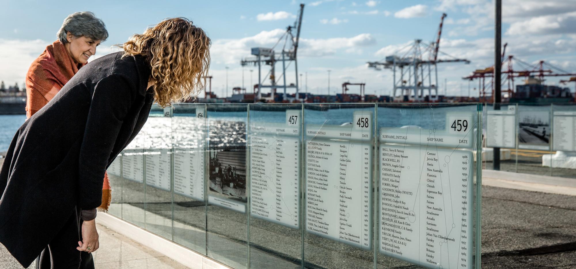 Two people examine the Welcome Walls in front of the WA Maritime Museum