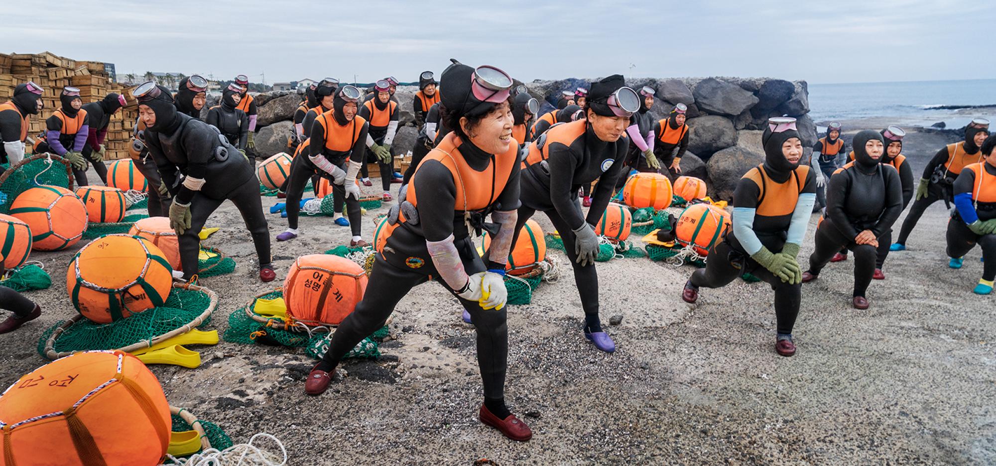 A group of female divers prepare to go into the ocean