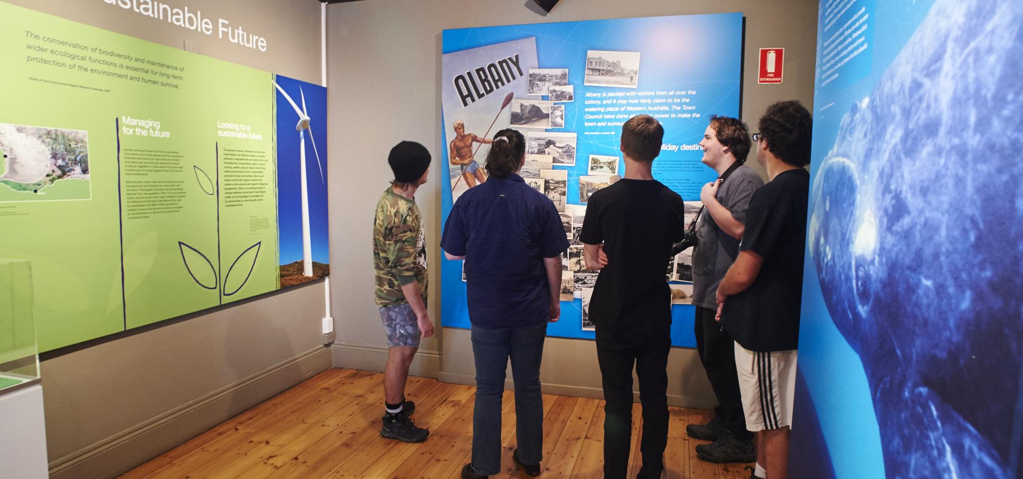 A group of young people examine a display in the Museum of the Great Southern