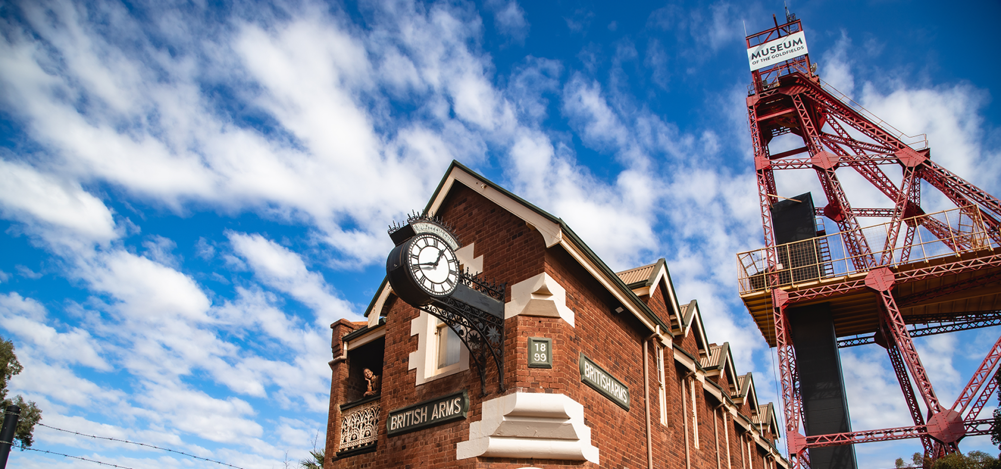 An old red brick building, the British Arms, stands beneath a large red tower