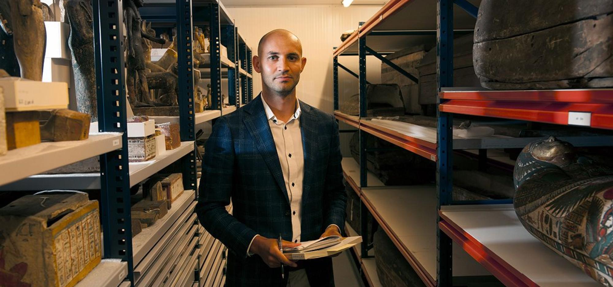 Photograph of Daniel with museum objects around him