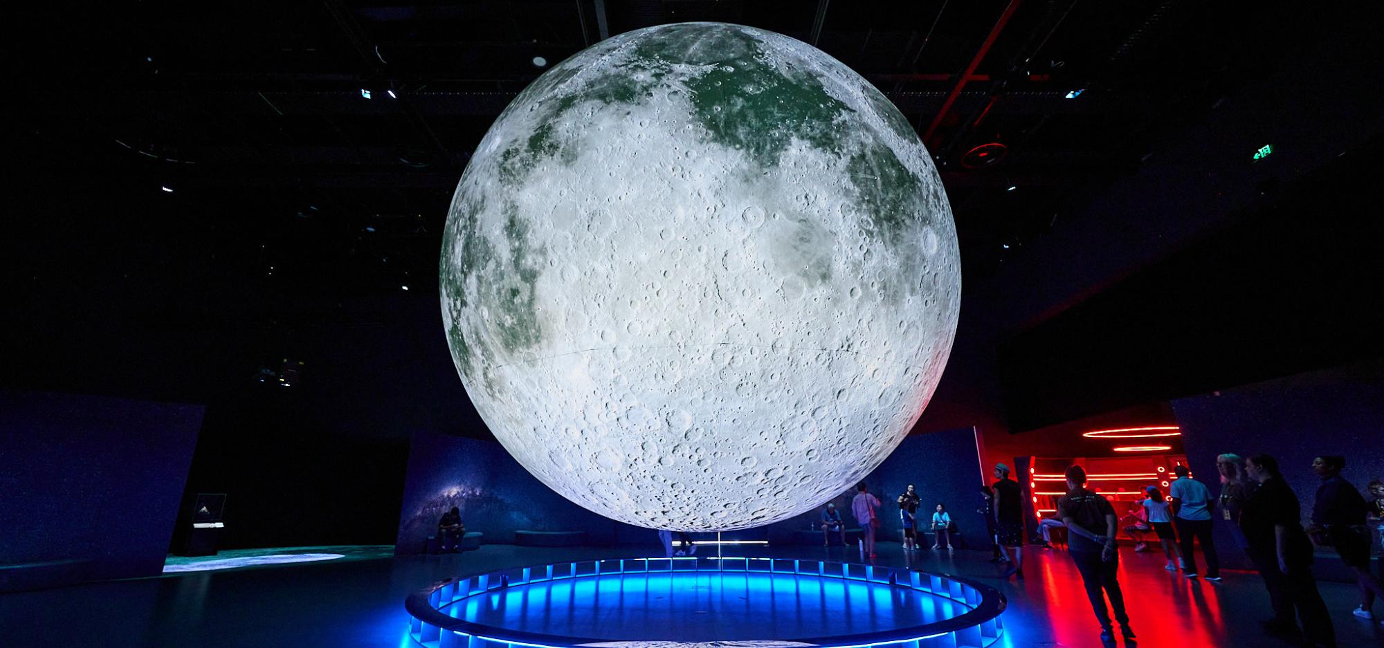 Large, impressive moon installation suspended in mid-air within an exhibition space