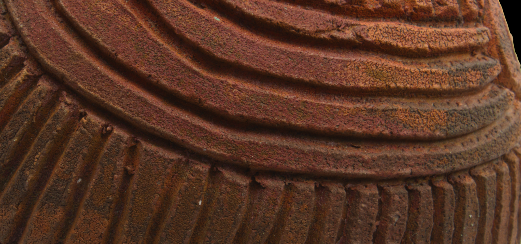 Close up detail of a brown pottery object with lines