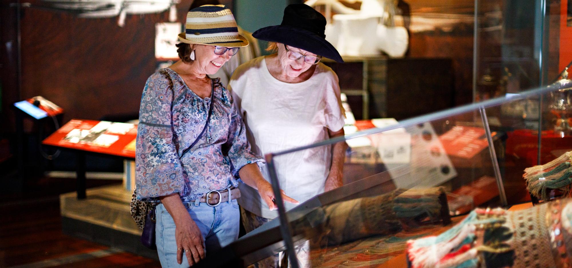 Two women examine an exhibit in a museum.
