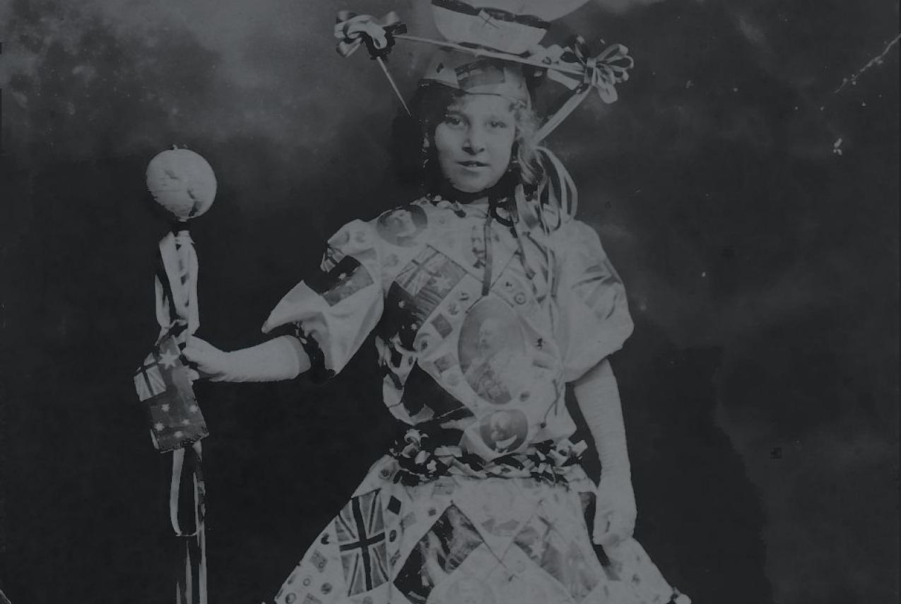 Girl wearing dress with hat that looks resembles a world globe