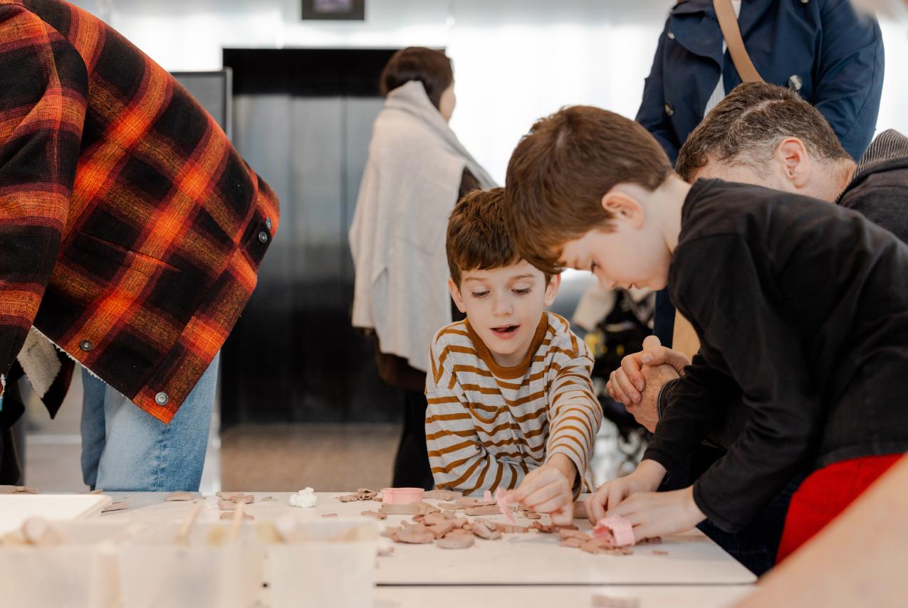Two young boys play with clay.