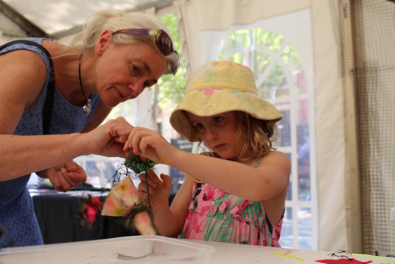 A woman and a young girl work on their contribution to the coral reef at AWESOME Festival